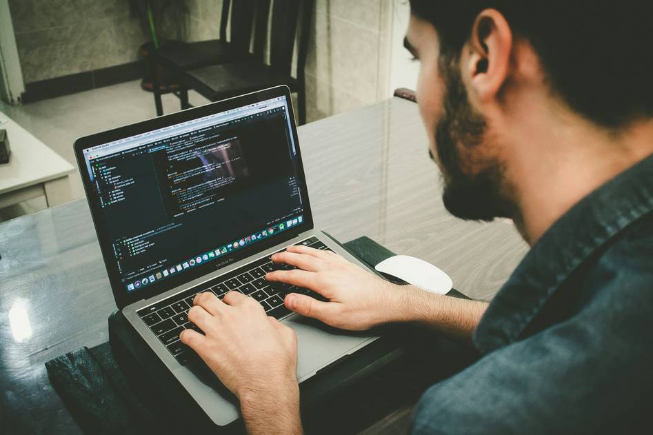 Smart contract code on a laptop screen with blockchain diagrams